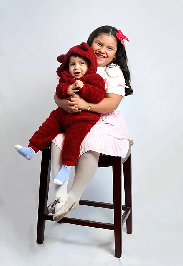 Two siblings posing together in the studio